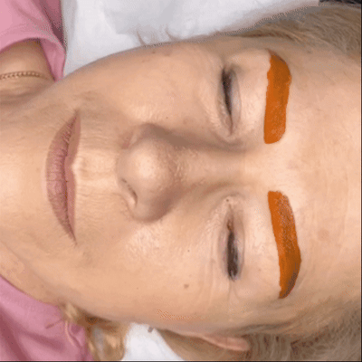 mouvement d'une cliente dont les sourcils sont recouverts d'un masque de pigment rouge pour réchauffer la couleur mouvement d'une cliente dont les sourcils sont recouverts d'un masque de pigment rouge pour réchauffer la couleur